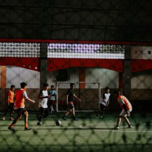group of people playing soccer on field during daytime